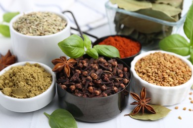 Photo of Different aromatic spices on white table, closeup