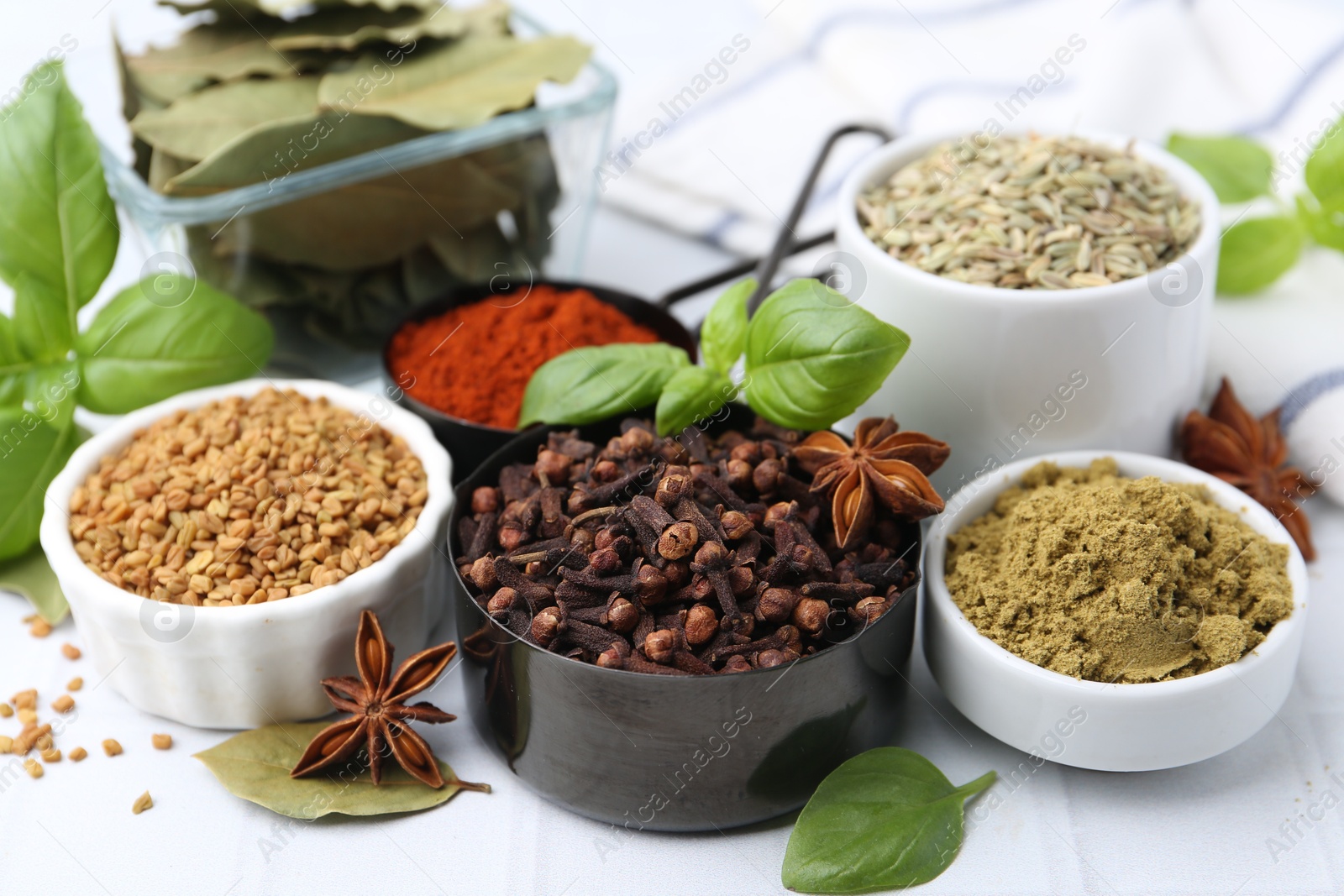 Different aromatic spices on white table, closeup Photo of Different aromatic spices on white table, closeup