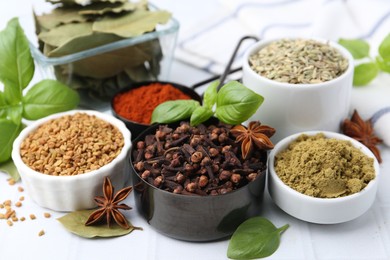 Photo of Different aromatic spices on white table, closeup