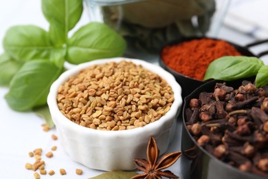 Photo of Different aromatic spices on white table, closeup