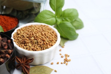 Photo of Different aromatic spices on white table, closeup. Space for text