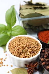 Photo of Different aromatic spices on white table, closeup