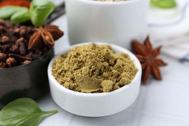 Photo of Different aromatic spices on white tiled table, closeup