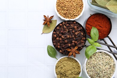 Photo of Different aromatic spices on white tiled table, flat lay. Space for text