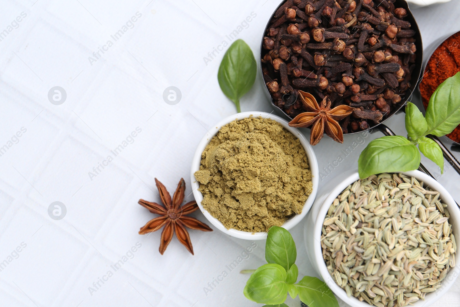 Different aromatic spices on white tiled table, flat lay. Space for text Photo of Different aromatic spices on white tiled table, flat lay. Space for text