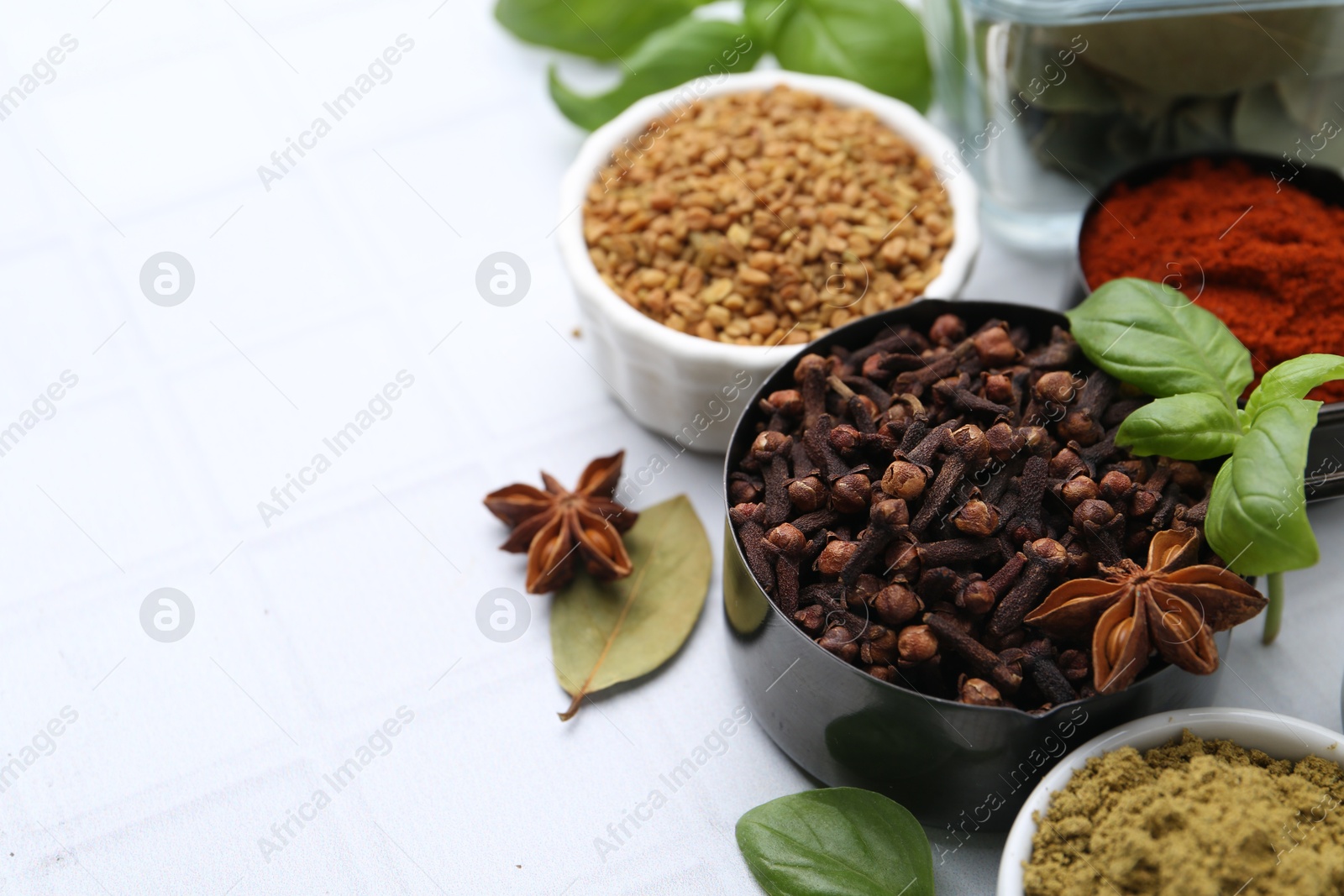 Different aromatic spices on white table, closeup. Space for text Photo of Different aromatic spices on white table, closeup. Space for text