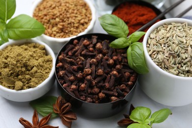 Photo of Different aromatic spices on white table, closeup