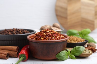Photo of Different aromatic spices on white table, closeup. Space for text