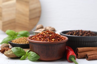 Photo of Different aromatic spices on white table, closeup. Space for text