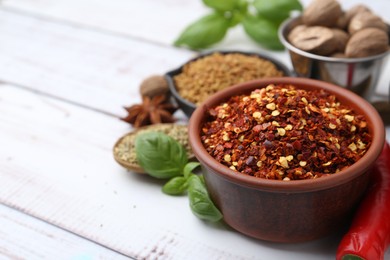 Photo of Different aromatic spices on white wooden table, closeup. Space for text