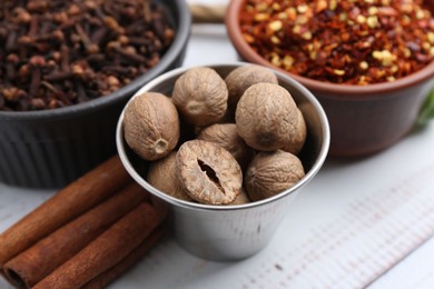 Photo of Different aromatic spices on white wooden table, closeup