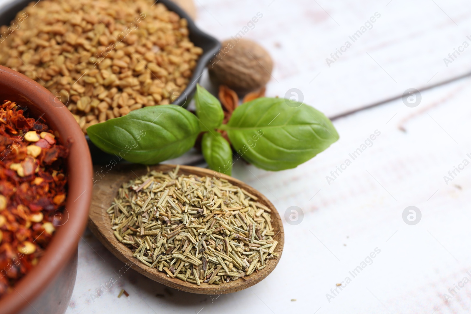 Different aromatic spices on white wooden table, closeup Photo of Different aromatic spices on white wooden table, closeup
