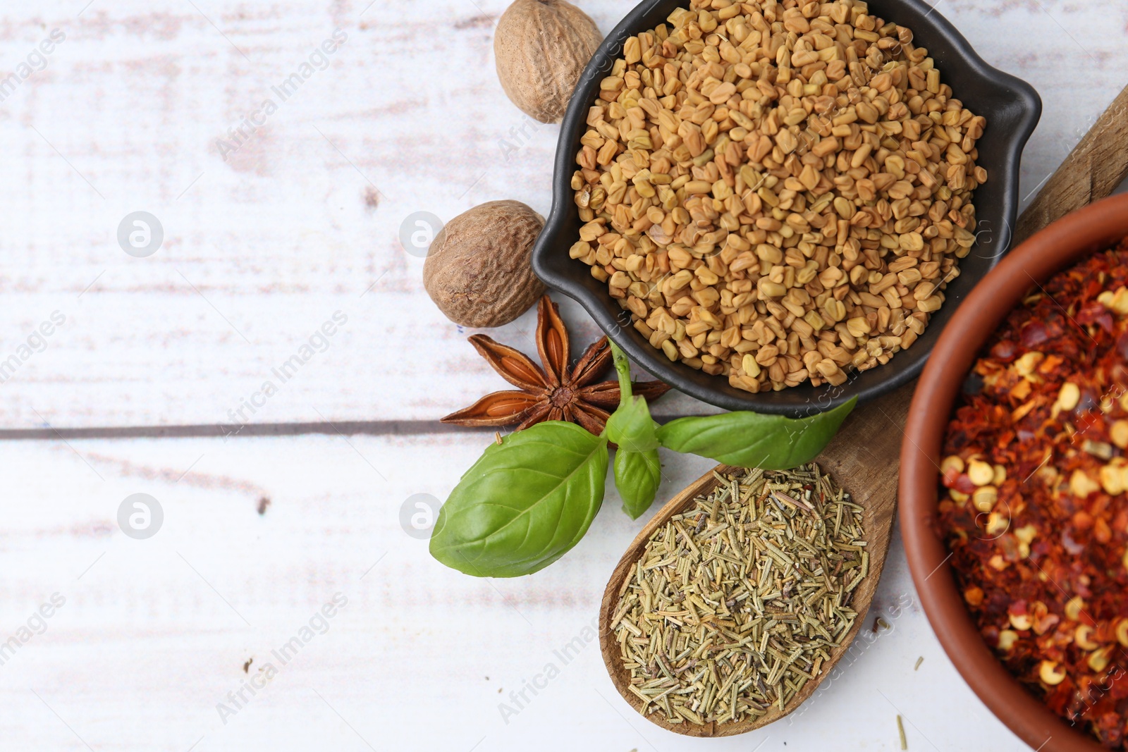 Different aromatic spices on white wooden table, flat lay. Space for text Photo of Different aromatic spices on white wooden table, flat lay. Space for text