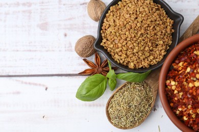 Photo of Different aromatic spices on white wooden table, flat lay. Space for text