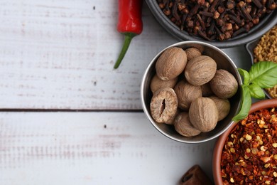 Photo of Different aromatic spices on white wooden table, flat lay. Space for text