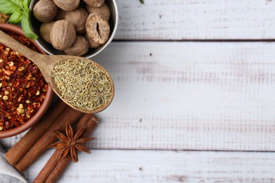 Photo of Different aromatic spices on white wooden table, flat lay. Space for text