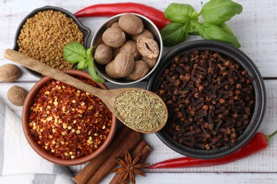 Photo of Different aromatic spices on white wooden table, flat lay