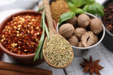 Photo of Different aromatic spices on white wooden table, closeup