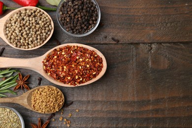 Photo of Different aromatic spices on wooden table, flat lay. Space for text