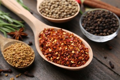 Photo of Different aromatic spices on wooden table, closeup