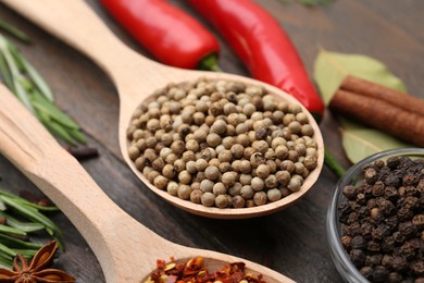 Photo of Different aromatic spices on wooden table, closeup