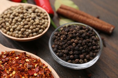 Photo of Different aromatic spices on wooden table, closeup