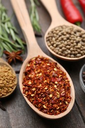 Photo of Different aromatic spices on wooden table, closeup