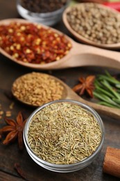 Photo of Different aromatic spices on wooden table, closeup