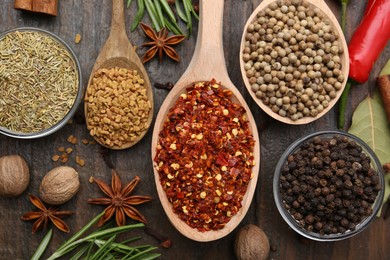 Photo of Different aromatic spices on wooden table, flat lay