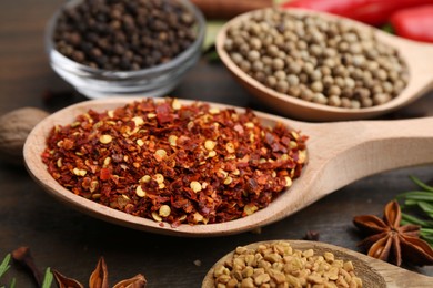 Photo of Different aromatic spices on wooden table, closeup