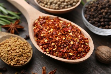 Photo of Different aromatic spices on wooden table, closeup