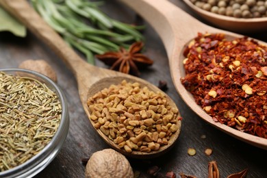 Photo of Different aromatic spices on wooden table, closeup