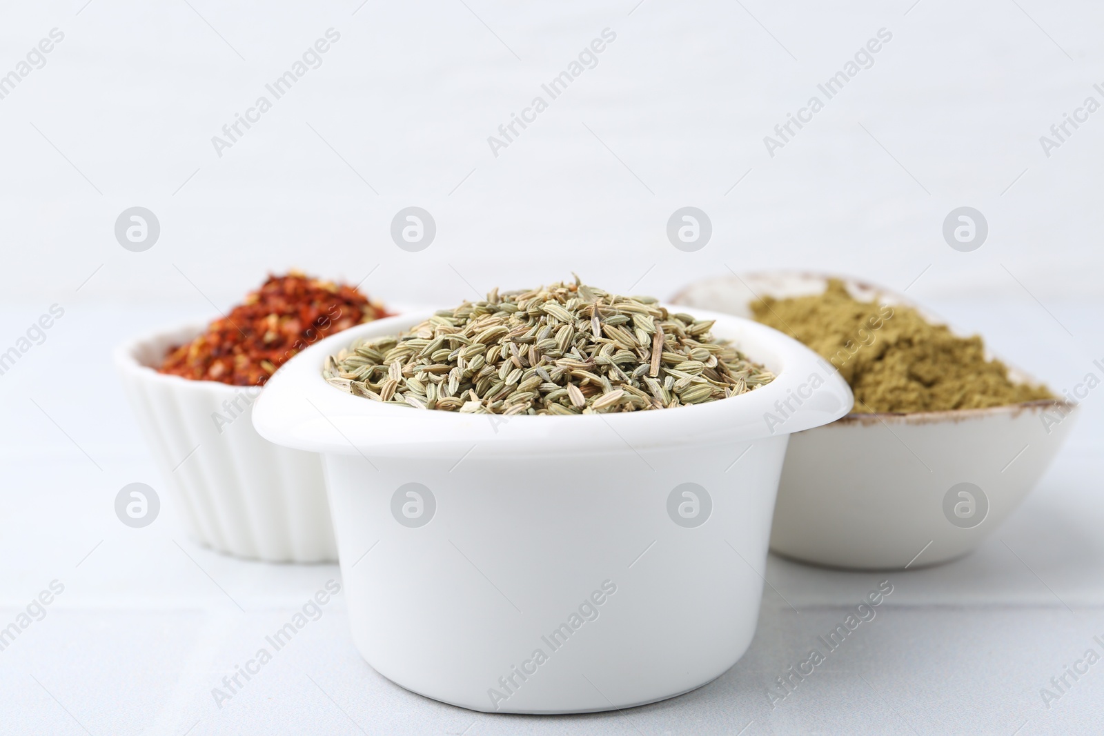 Different aromatic spices on white tiled table, closeup Photo of Different aromatic spices on white tiled table, closeup