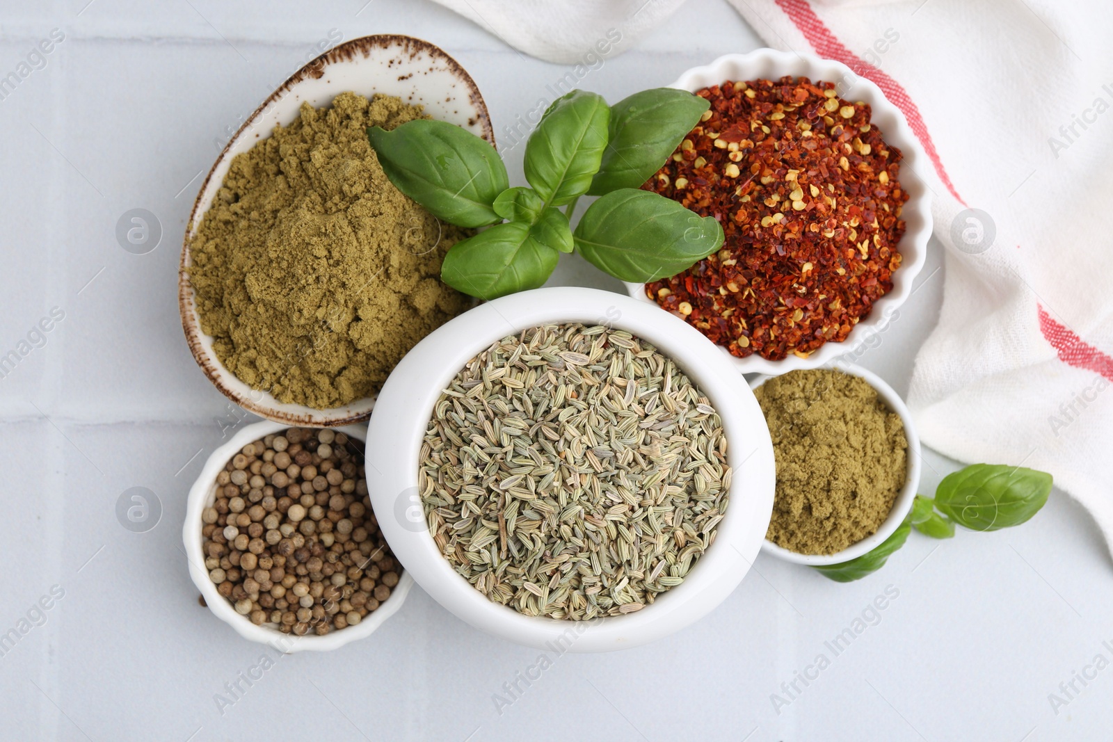 Different aromatic spices on white tiled table, flat lay Photo of Different aromatic spices on white tiled table, flat lay