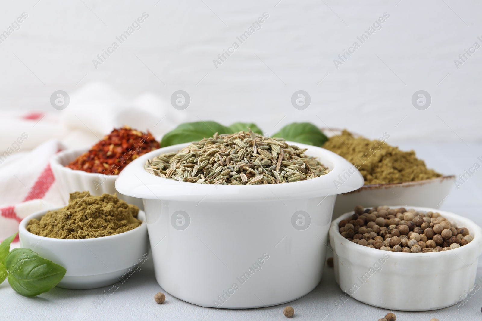 Different aromatic spices on white tiled table, closeup Photo of Different aromatic spices on white tiled table, closeup