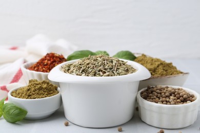 Photo of Different aromatic spices on white tiled table, closeup