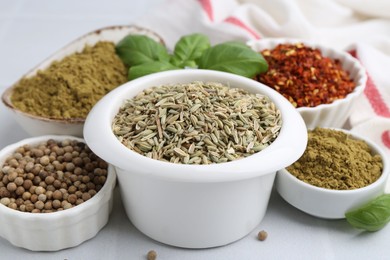 Photo of Different aromatic spices on white tiled table, closeup