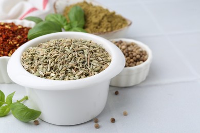 Photo of Different aromatic spices on white tiled table, closeup