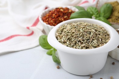 Photo of Different aromatic spices on white tiled table, closeup