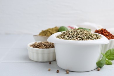Photo of Different aromatic spices on white tiled table, closeup. Space for text