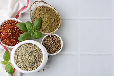 Photo of Different aromatic spices on white tiled table, flat lay. Space for text