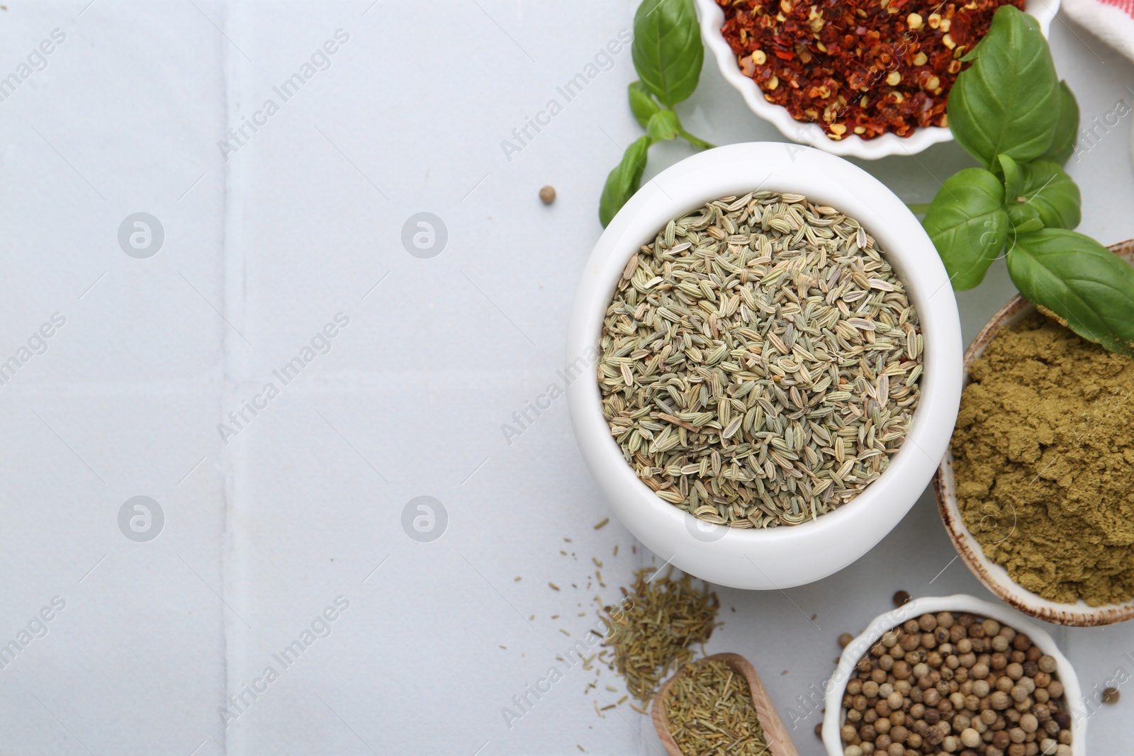 Photo of Different aromatic spices on white tiled table, flat lay. Space for text
