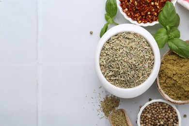 Photo of Different aromatic spices on white tiled table, flat lay. Space for text