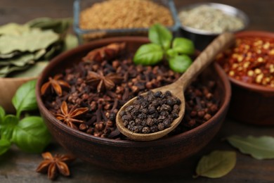 Photo of Different aromatic spices on wooden table, closeup