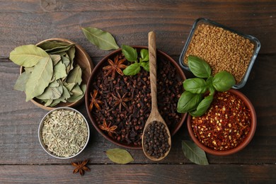 Photo of Different aromatic spices on wooden table, flat lay