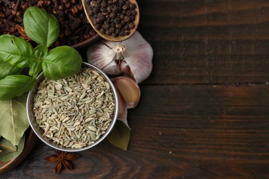 Photo of Different aromatic spices on wooden table, flat lay. Space for text