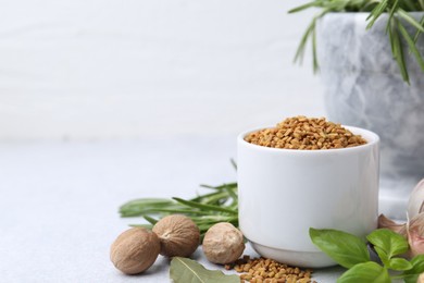 Photo of Different aromatic spices on grey table against light background, closeup. Space for text