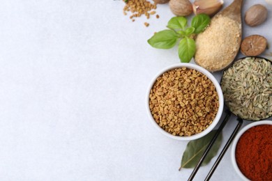 Photo of Different aromatic spices on light grey table, flat lay. Space for text