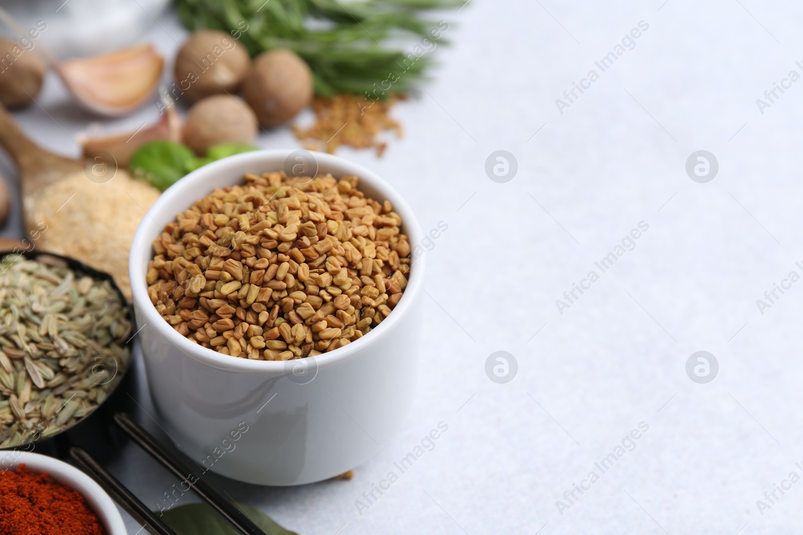 Different aromatic spices on light grey table, closeup. Space for text Photo of Different aromatic spices on light grey table, closeup. Space for text
