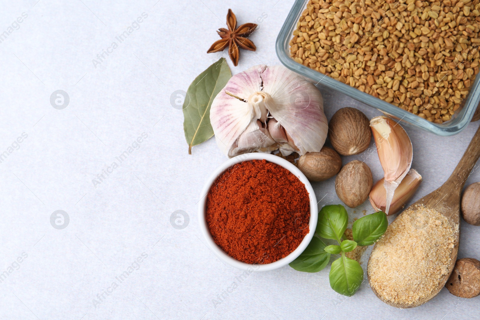 Different aromatic spices on light grey table, flat lay. Space for text Photo of Different aromatic spices on light grey table, flat lay. Space for text